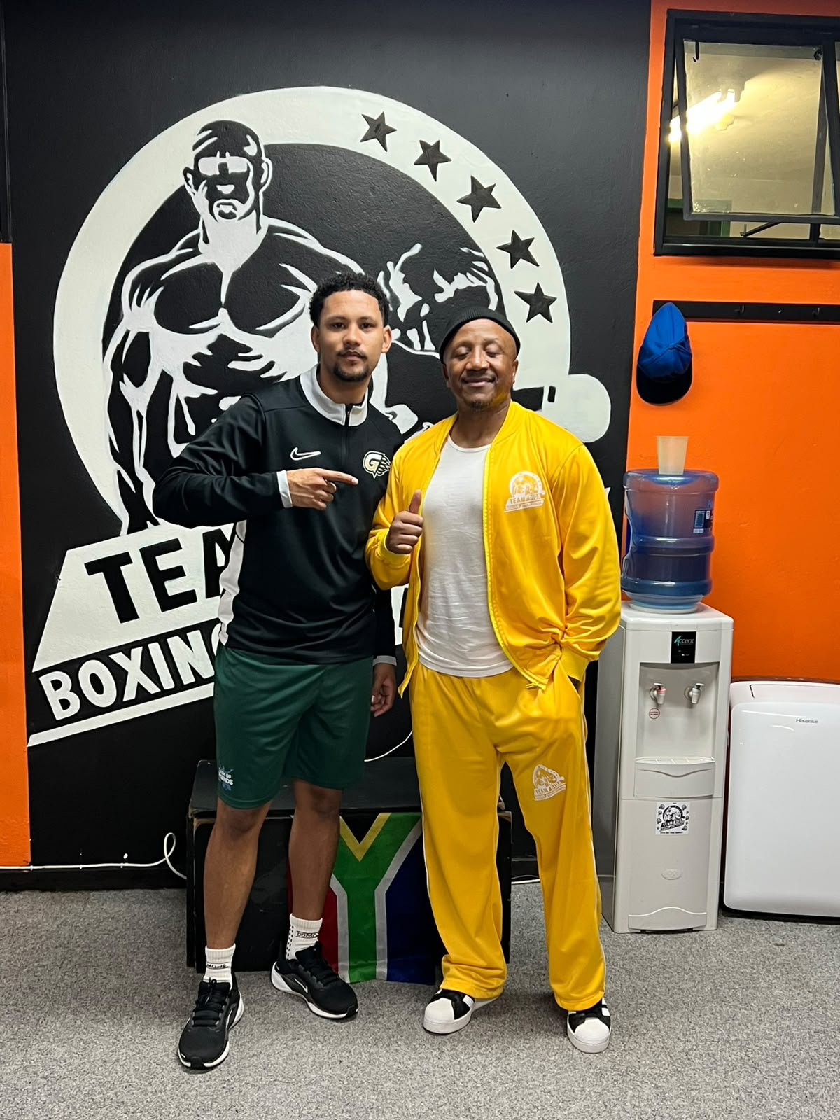 Team Dida gym members in front of the gym mural
